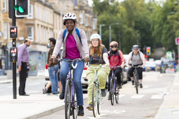 People cycling on the South City Way cycle route on Victoria Road in Glasgow