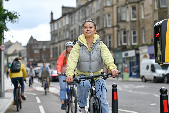 People cycle on a bidirectional, deparated cycle lane in Edinburgh